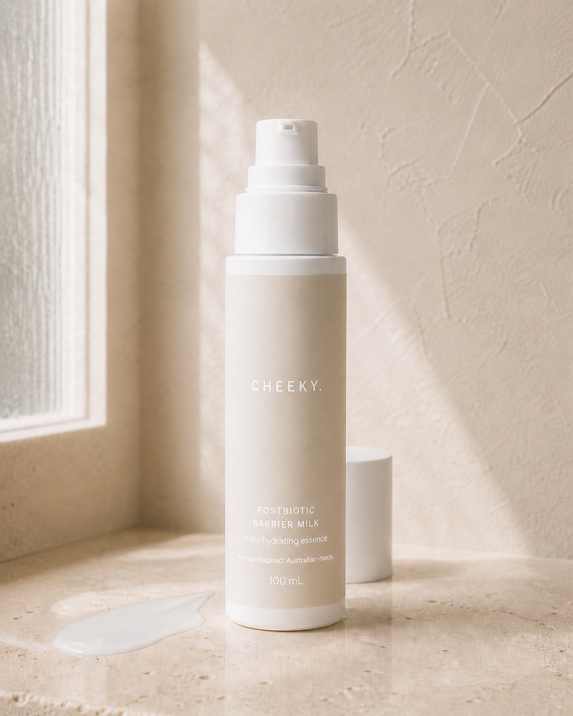 CHEEKY Postbiotic Barrier Milk 100 mL airless pump bottle concept with a warm oat label and white lettering